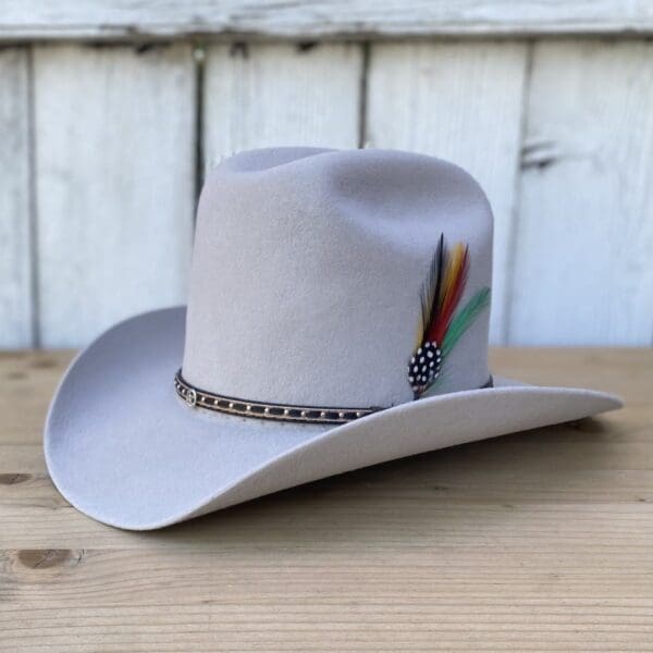 A cowboy hat with feathers on it sitting on top of a table.