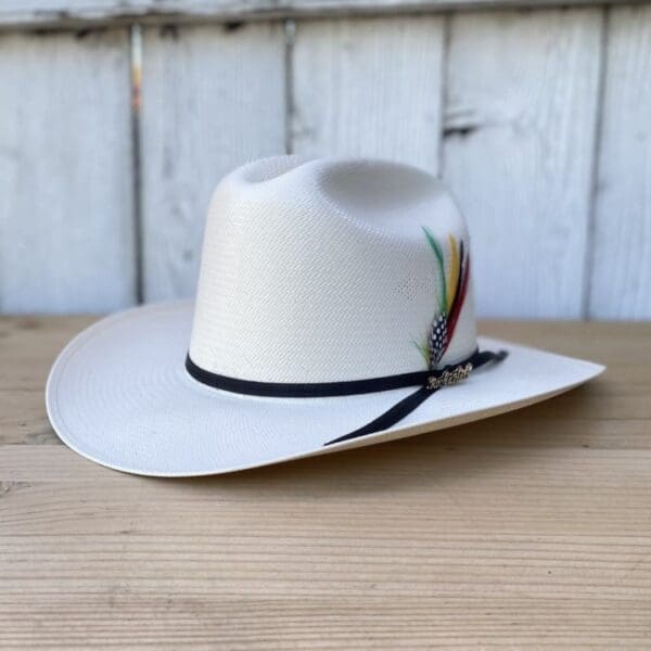 A white cowboy hat sitting on top of a wooden table.