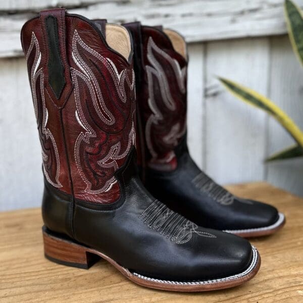 A pair of cowboy boots sitting on top of a wooden table.