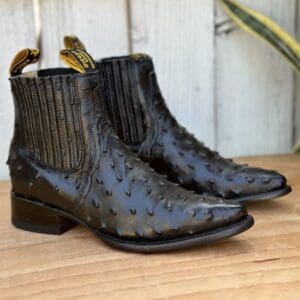 A pair of black boots sitting on top of a wooden floor.