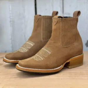 A pair of brown boots sitting on top of a wooden table.