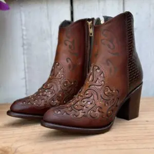 A pair of brown boots sitting on top of a wooden table.