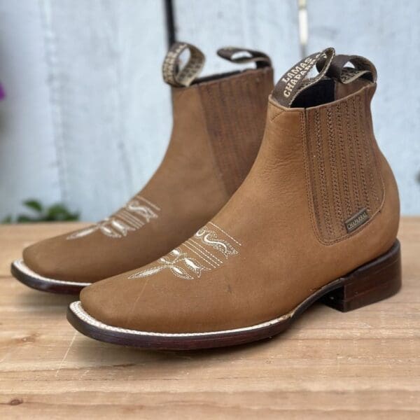 A pair of boots sitting on top of a wooden table.