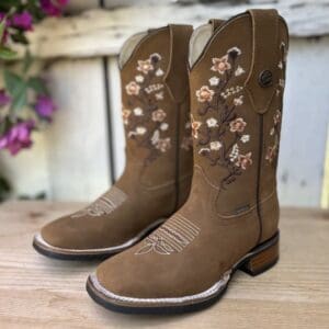 A pair of brown cowboy boots with flowers on them.