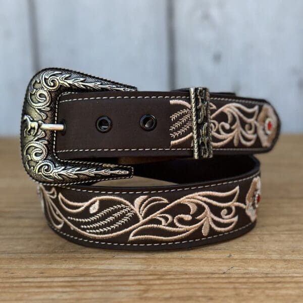 A brown and white belt sitting on top of a wooden table.