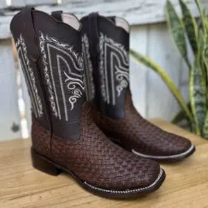 A pair of cowboy boots sitting on top of a wooden table.