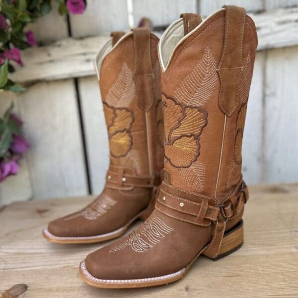 A pair of cowboy boots sitting on top of a wooden table.