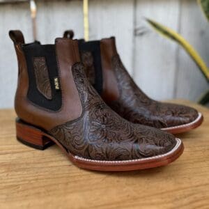 A pair of brown boots sitting on top of a wooden table.