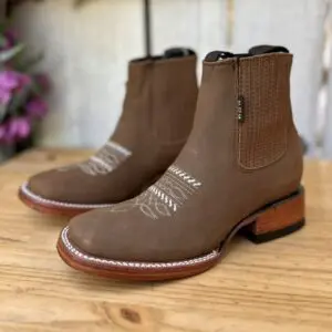 A pair of brown boots sitting on top of a wooden table.