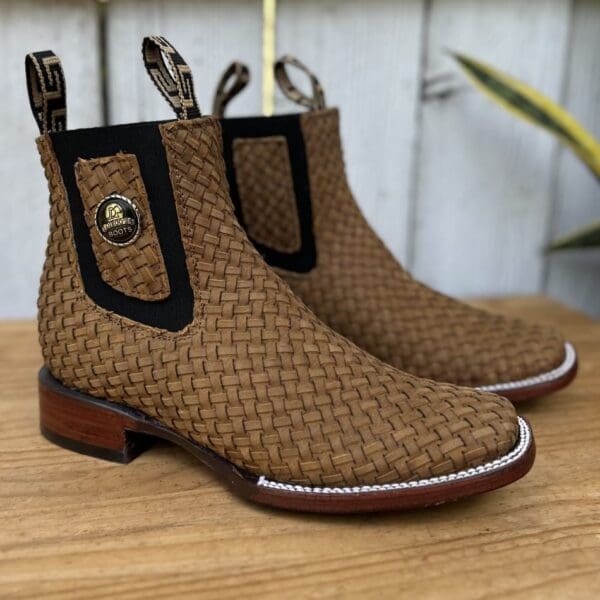 A pair of brown boots sitting on top of a wooden table.