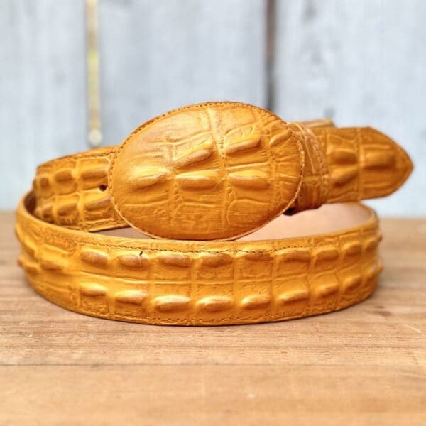 A gold belt sitting on top of a wooden table.