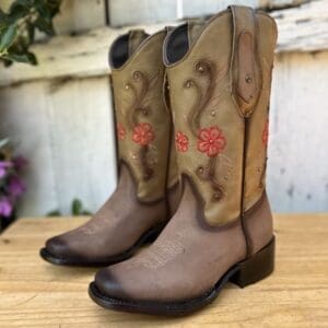 A pair of cowboy boots sitting on top of a wooden table.