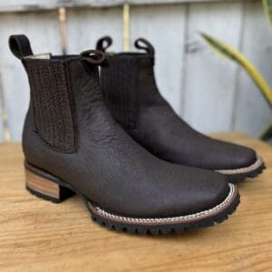 A pair of black boots sitting on top of a wooden table.