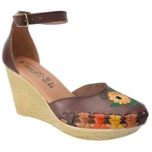 A brown wedge sandal with flowers on it.