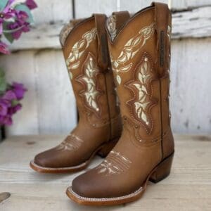 A pair of cowboy boots sitting on top of a wooden table.