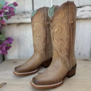 A pair of cowboy boots sitting on top of a wooden table.