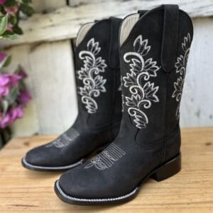 A pair of black cowboy boots sitting on top of a table.